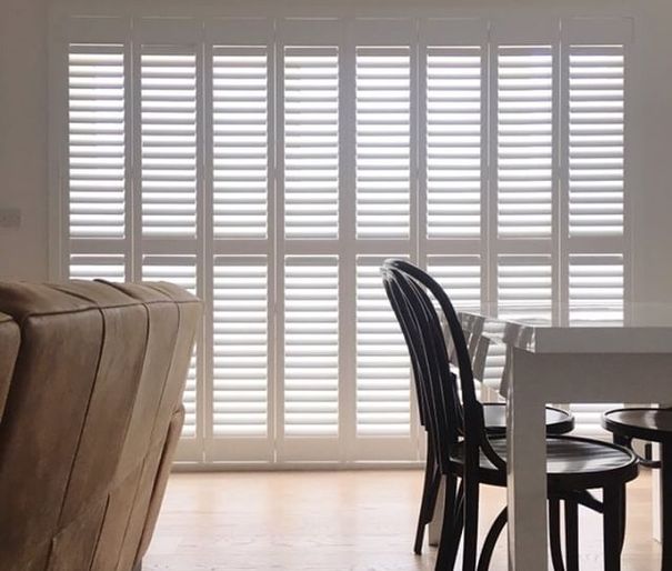 white tracked shutters in dining room