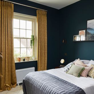 textured shimmering gold curtains hanging on double hung window in blue bed room