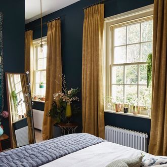 textured shimmering gold curtains hanging on double hung window in blue bed room