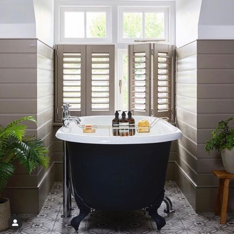 Brown shutters in a bathroom decorated with brown tiles