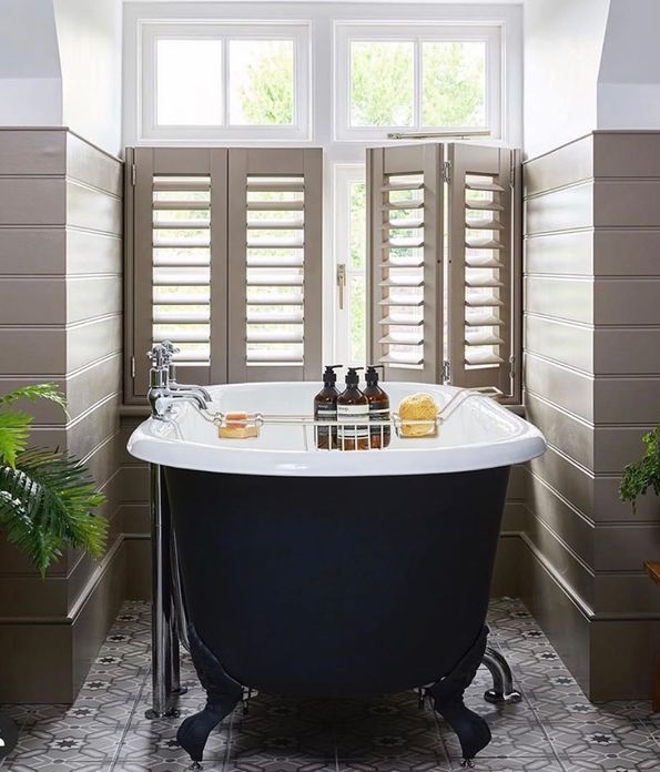 Brown shutters in a bathroom decorated with brown tiles