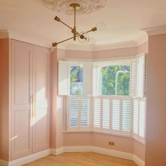 white tier on tier shutters with tilt bars in pink bed room