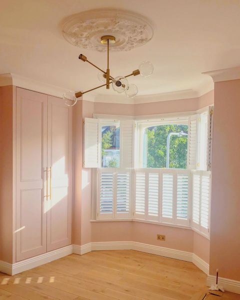 white tier on tier shutters with tilt bars in pink bed room