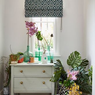 The green geo printed roman blinds hanging on the window in hallway