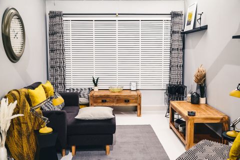 Cadillac Noir curtains with white Venetian blinds in living room