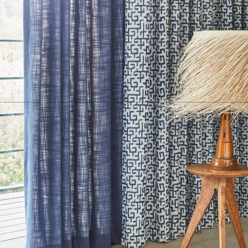 blue unlined curtain and white curtains featuring blue retro print hanging on doors in bedroom