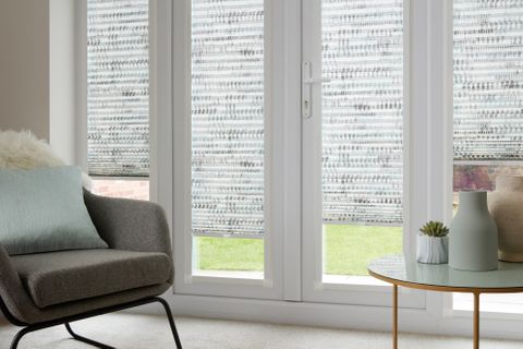 Duo natural Thermashade Perfect Fit Pleated blinds from House Beautiful range dressed on bi-fold doors of living room.
