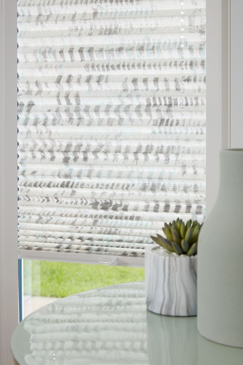 Close up of duo natural Thermashade Perfect Fit Pleated blinds dressed on bifold doors of living room.