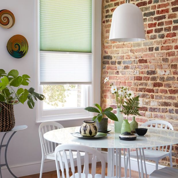 Mint green and sheer white Transition Pleated blinds dressed on the window in dining room.