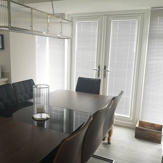 angled shot of dining room showing perfect fit window blind of silver venetian blinds
