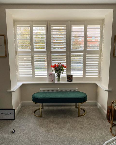 Front on shot of bay window featuring white full height shutters