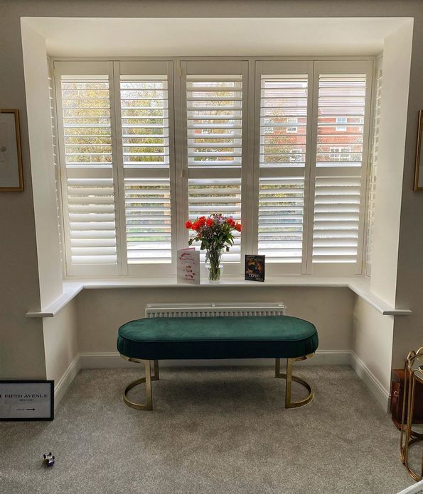 Front on shot of bay window featuring white full height shutters