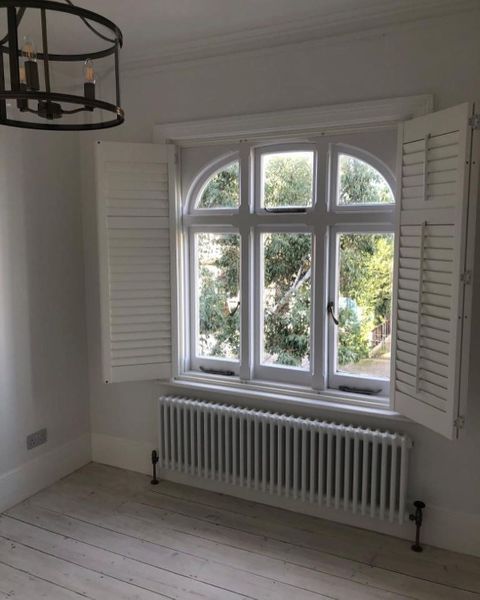 Front picure of new opened  white shutters intalled in window