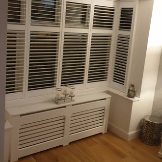 Front picure of new bay white shutters intalled in window