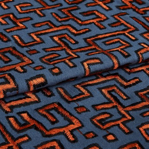 Grey background and orange embrodiered folded fabric in living etc 