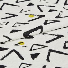 Serra Ochre fabric swatch featuring black geometric shapes on white background