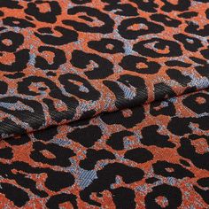 Wild Sienna fabric swatch featuring black leopard print on grey and orange background