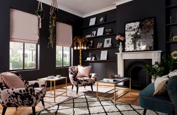 blush pink roman blinds in a living room with dark decor and black walls 