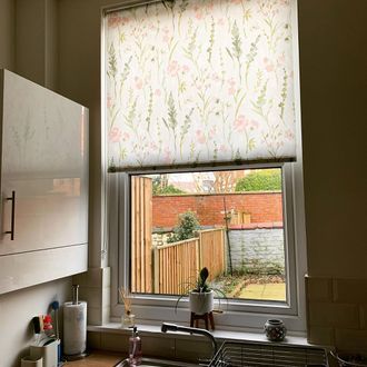 Roller blinds featuring penny rose print hanging on the kitchen window