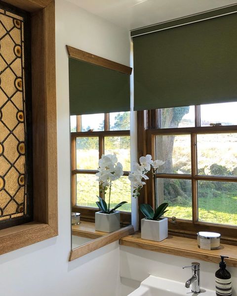 Green roller blinds dressed on the window of bathroom
