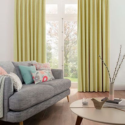 Furnished living room with Lotta Citron curtains over a glass door