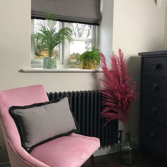 Garratt Peat Roman blind in modern dressing room with pink seat and black chest of drawers with a plant 