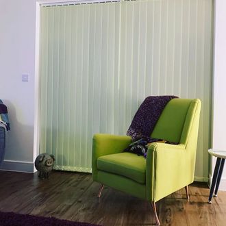 Light Green Vertical blind behind lime green chair in living room 