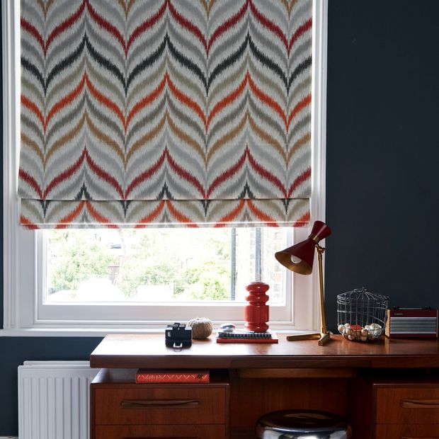 white blue and orange patterned blind in navy blue home office with mid century modern style desk