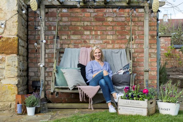 Jo Whiley outdoors on bench swing with pastel coloured blankets