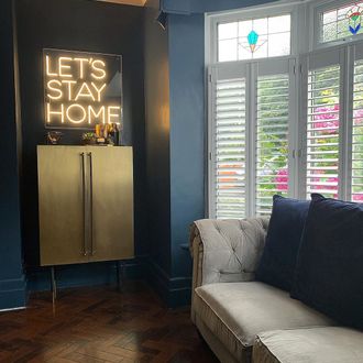 Pure White Shutters in living room with lets stay home sign
