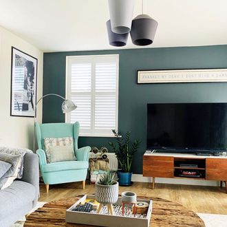 white shutters in living room with blue walls and small blue seat
