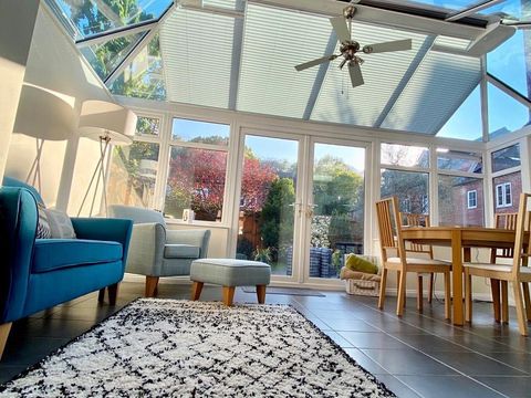 conservatory roof with blue sofa, black and white rug and dining table
