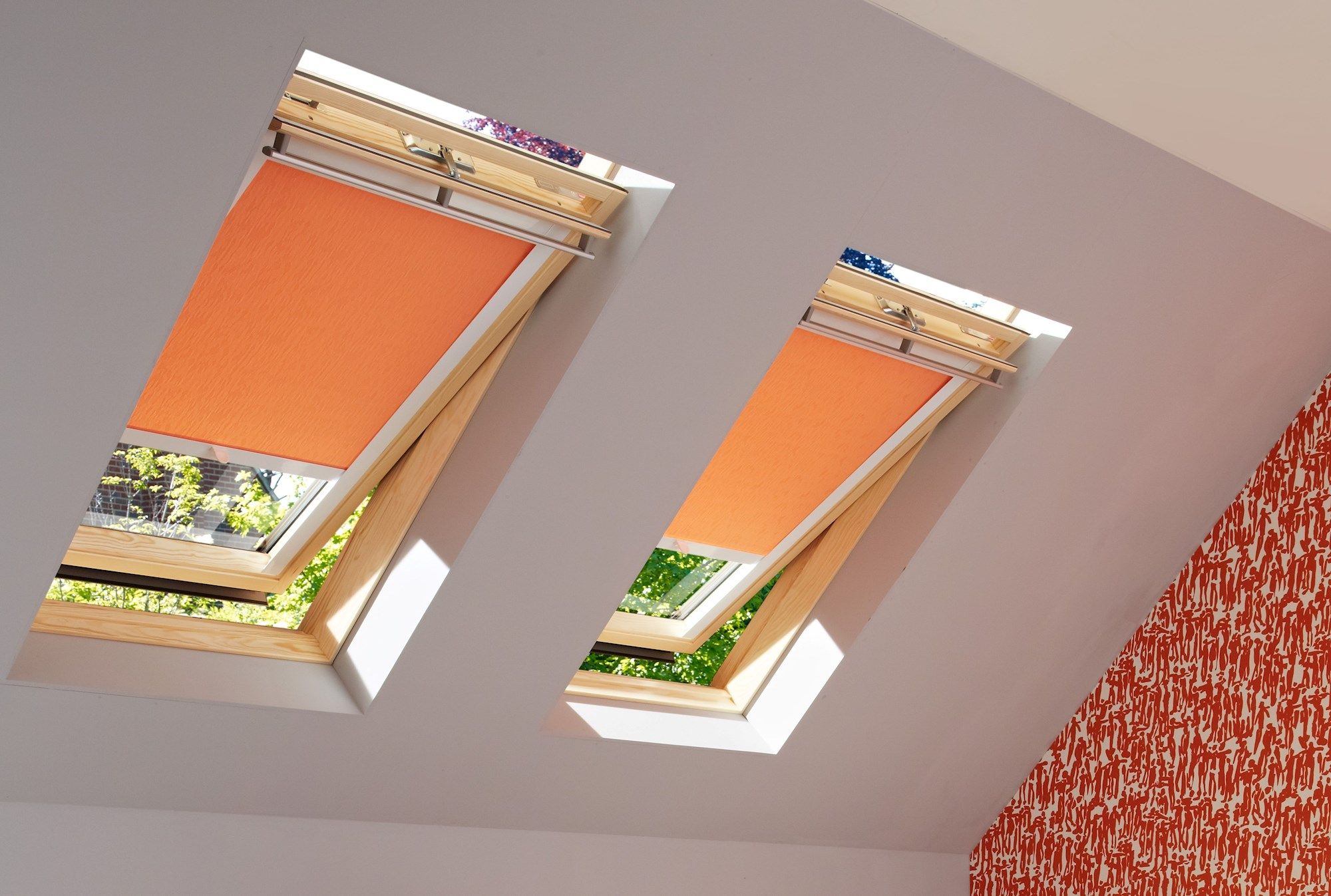 an image showing how two skylight blinds in a bright orange fit perfectly to skylight windows 