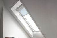 A blue coloured skylight fitted blind on a small window above a staircase landing