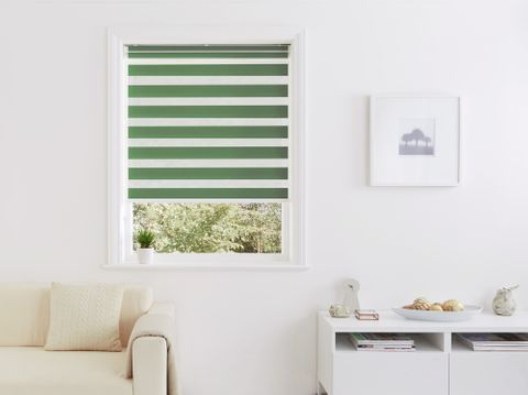 green striped Day and Night blind in small window with cream sofa