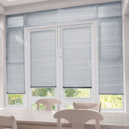 Sheer Luxury Pinstripe Perfect Fit venetian blinds on four French Doors in a sleek dining area. The blinds are Silver and contrast against white dining room furniture with a cream topped dining table.
