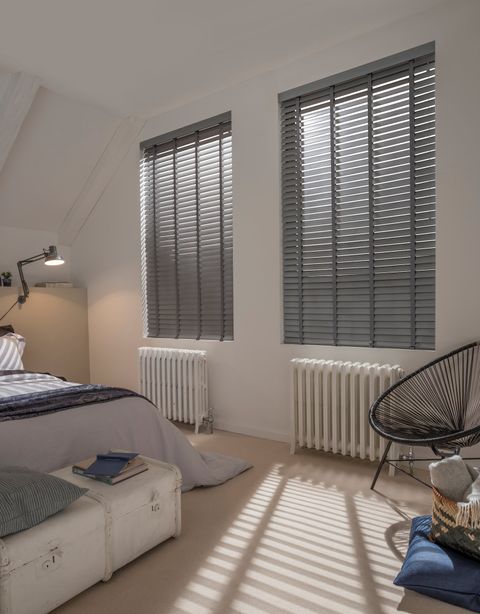 Dark grey lunaire faux wooden blinds in light bedroom with contemporary furniture
