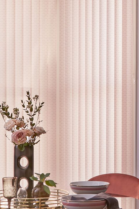 Blush pink vertical blinds in dining room with mirrored table and tray with blush pink roses in vase
