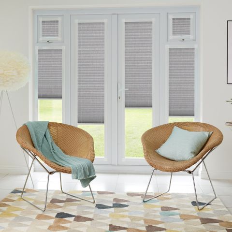Grey pleated perfect fit blinds in patio door windows with light rattan style desk chairs with dug egg blue accessories