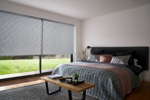 A Grey Patterned Roller Blind in Silver in a one bed Bedroom