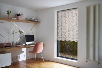 home office with orange and cream patterned blind with pink desk chair and gold accessories