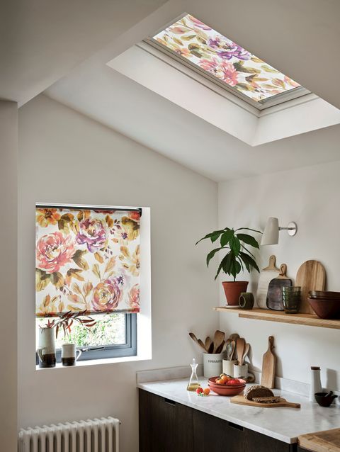 Marble kitchen with a floral blind and wooden furnishings
