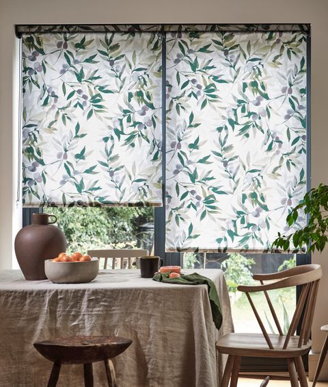 An earthy dining room with a white and green blind and fitting furnishings