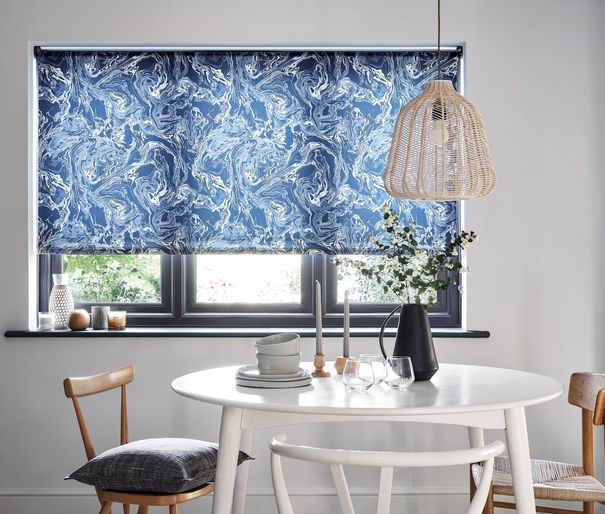 A monochrome dining room with a marble blue blind and wooden furniture