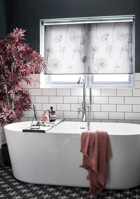 a striking monochrome bathroom with a neutral floral blind and blush pink highlights from the furnishings
