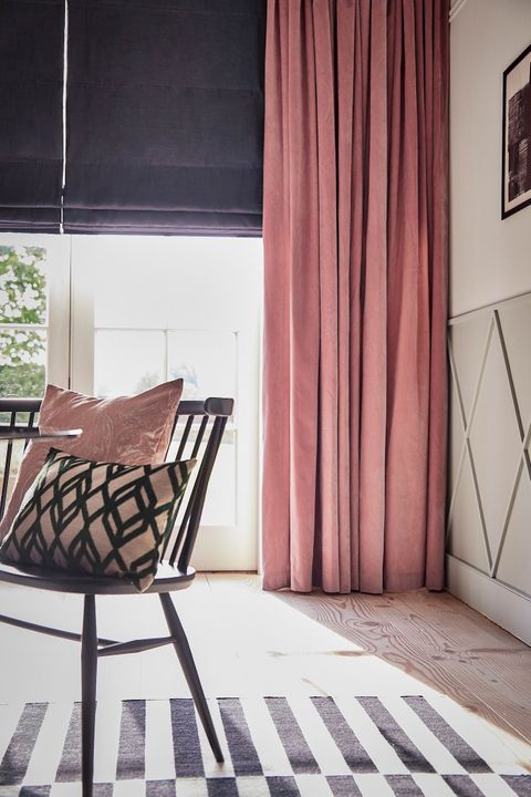 Rose pink velvet curtains over a dark roman blind in a light dining room