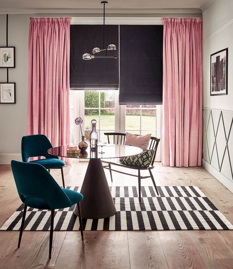 Velvet rose pink curtains over a dark roman blind in a modern, bright living room