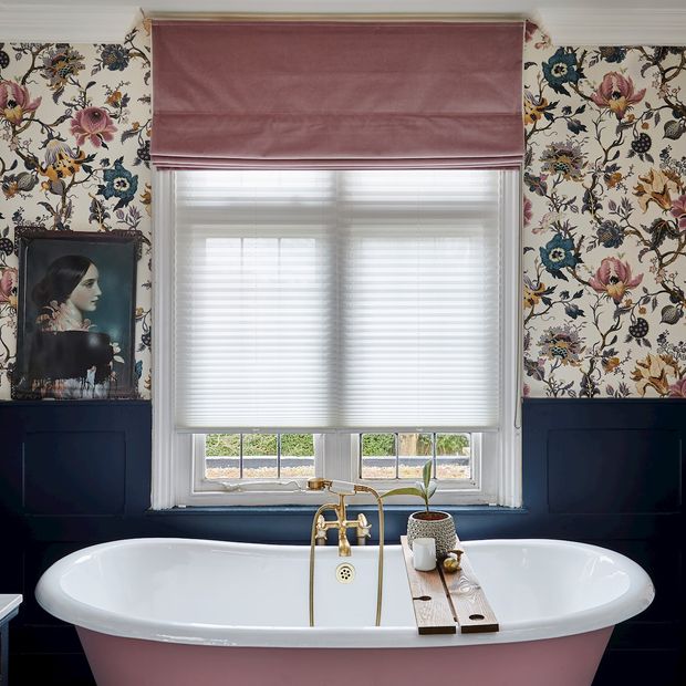 Rose pink, velvet roman blind over light, pleated blinds in a floral bathroom with rose pink and navy accents