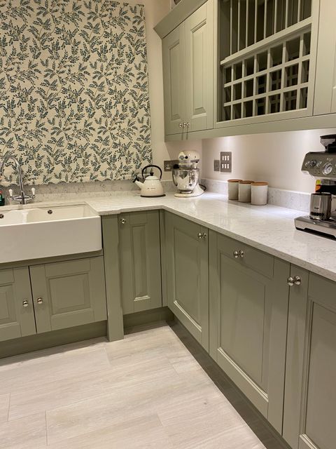 Leaf print green and white roman blind in a neutral kitchen with white accents