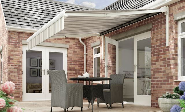 Hardelot Beige awning gives garden patio area shade with rattan dining table